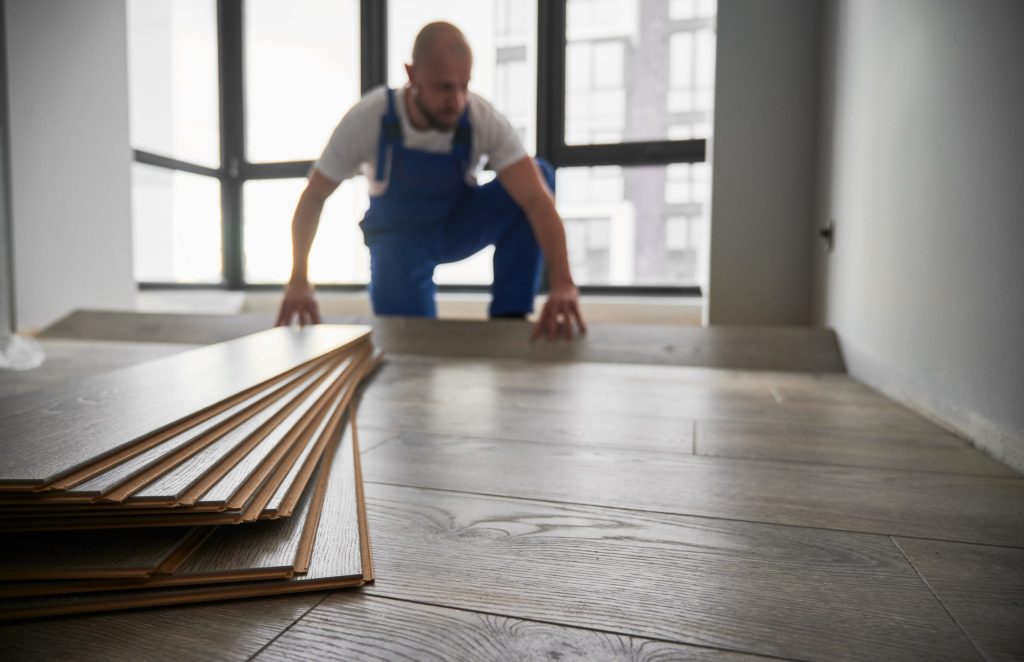 laminate planks and male flooring installer on bac 2023 04 03 19 25 14 utc scaled 1